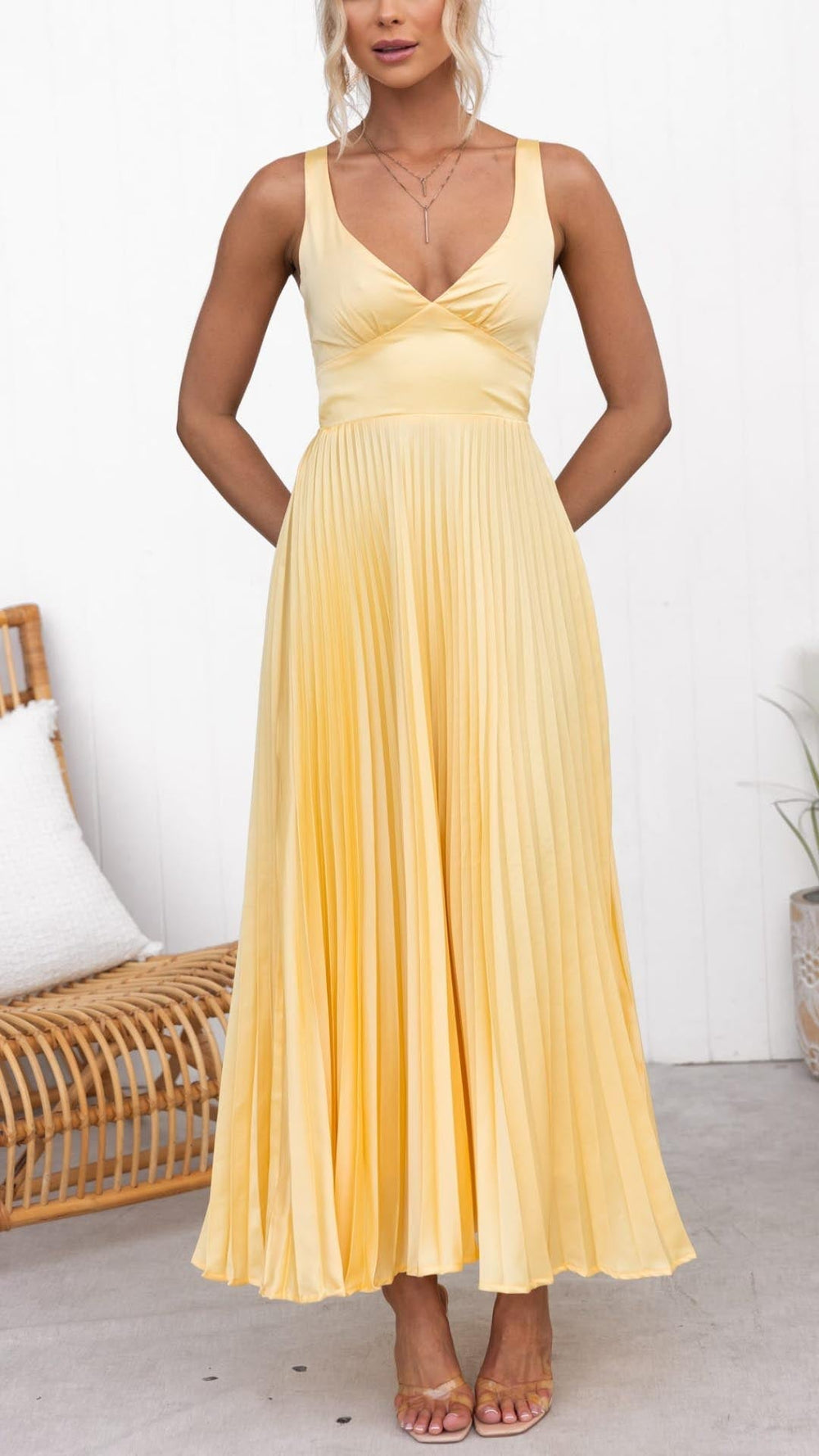 Female model showing a flowy dress with crisscross back straps.