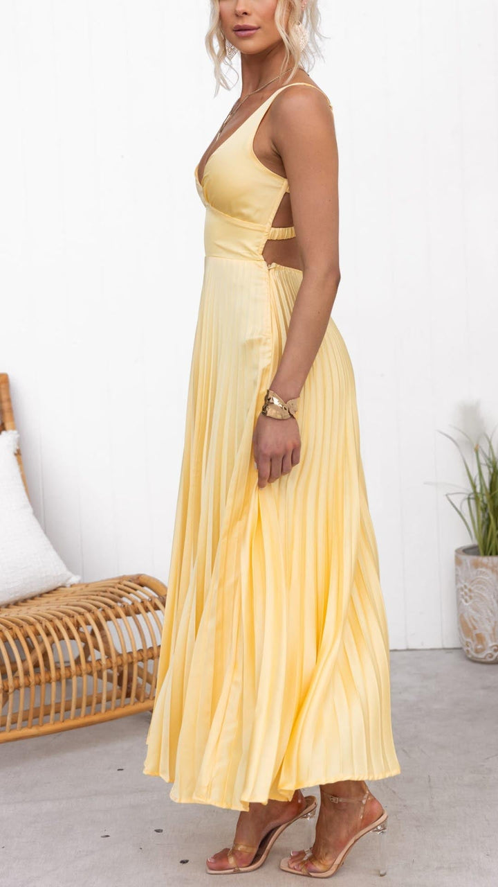 Woman standing in a cinched waist midi dress on a plain background.