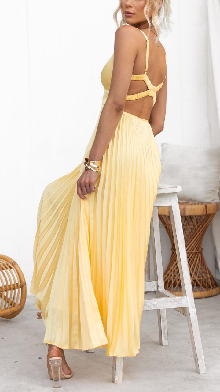 Female model wearing a V-neck pleated dress with graceful movement.