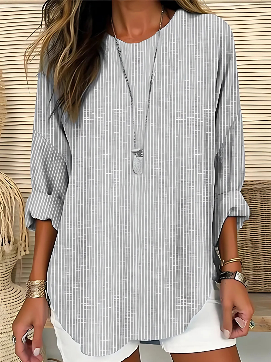 Woman wearing a long-sleeved striped top with a relaxed silhouette.