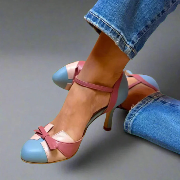 Woman wearing elegant pumps in side view on plain background.