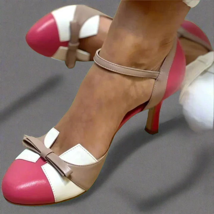 Female model showcasing pointed pumps from front angle on plain background.
