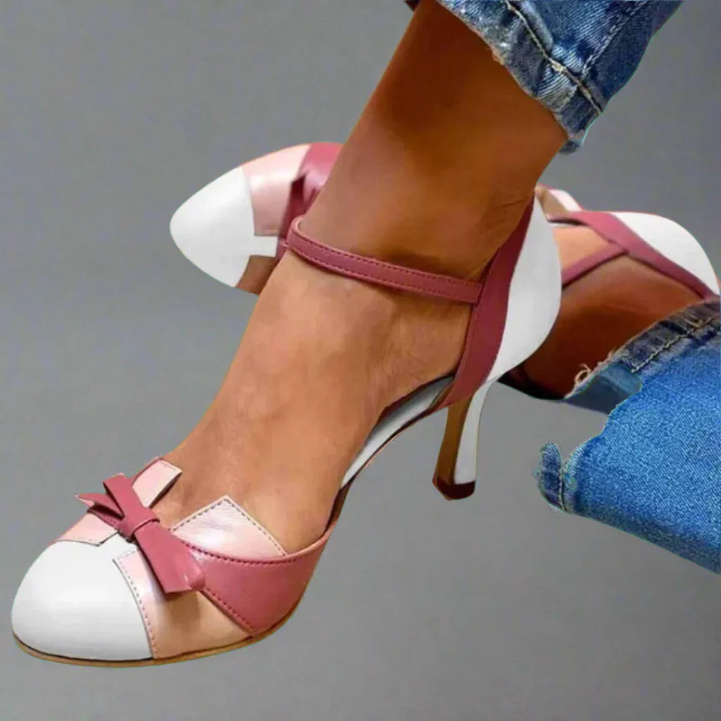 Woman posing in chic pumps with side profile plain background.
