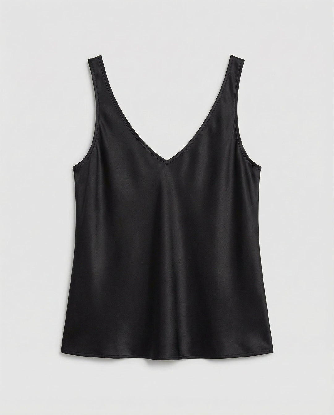 Woman showcasing a lightweight layering top against a plain background.
