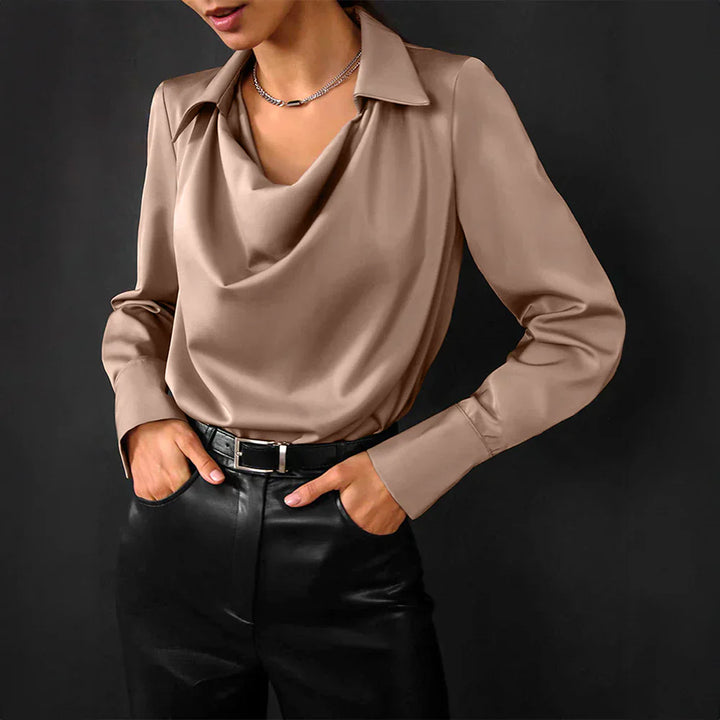 Female model showcasing a polished long sleeve blouse on a plain background.