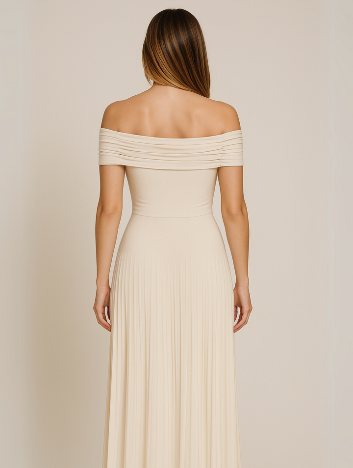 
Female model showcasing a long pleated dress with an elegant silhouette against a plain backdrop.