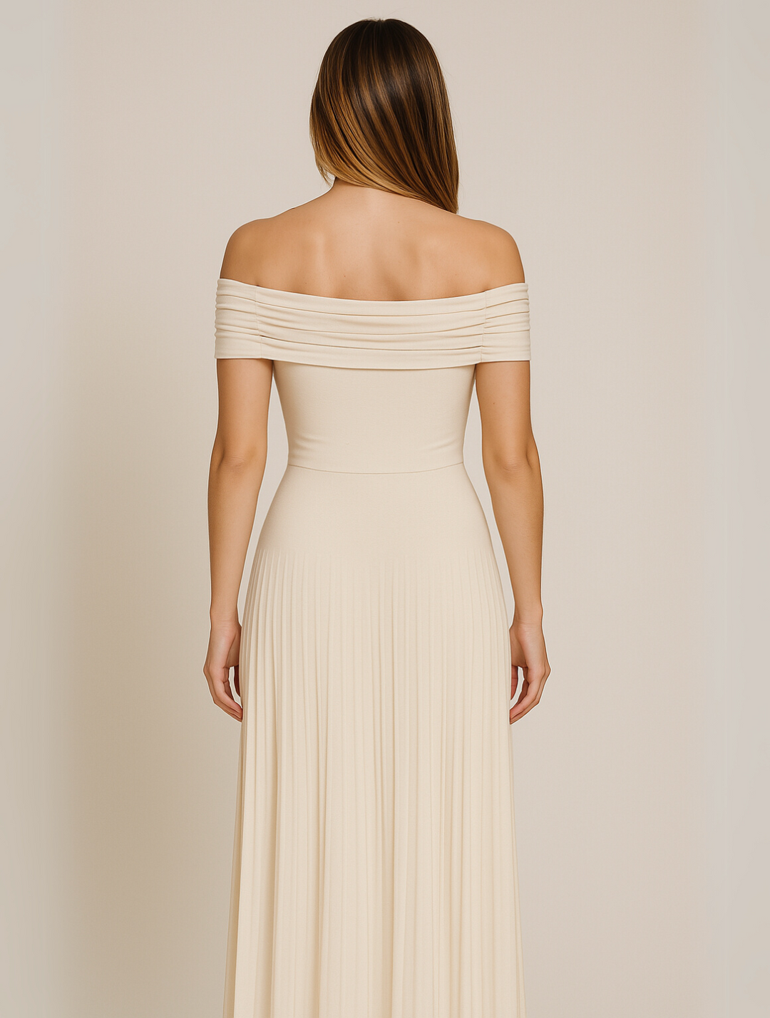 Female model back angle in pleated dress on gray background.