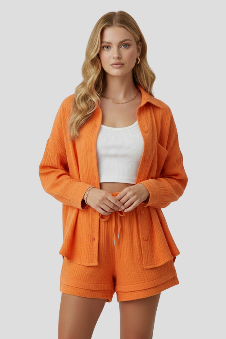 Woman wearing textured blouse and shorts set on plain gray background