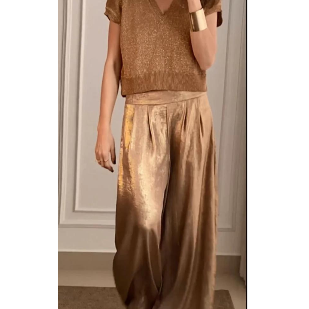 Female model wearing a V-neck two-piece set with wide-leg trousers on a plain background.