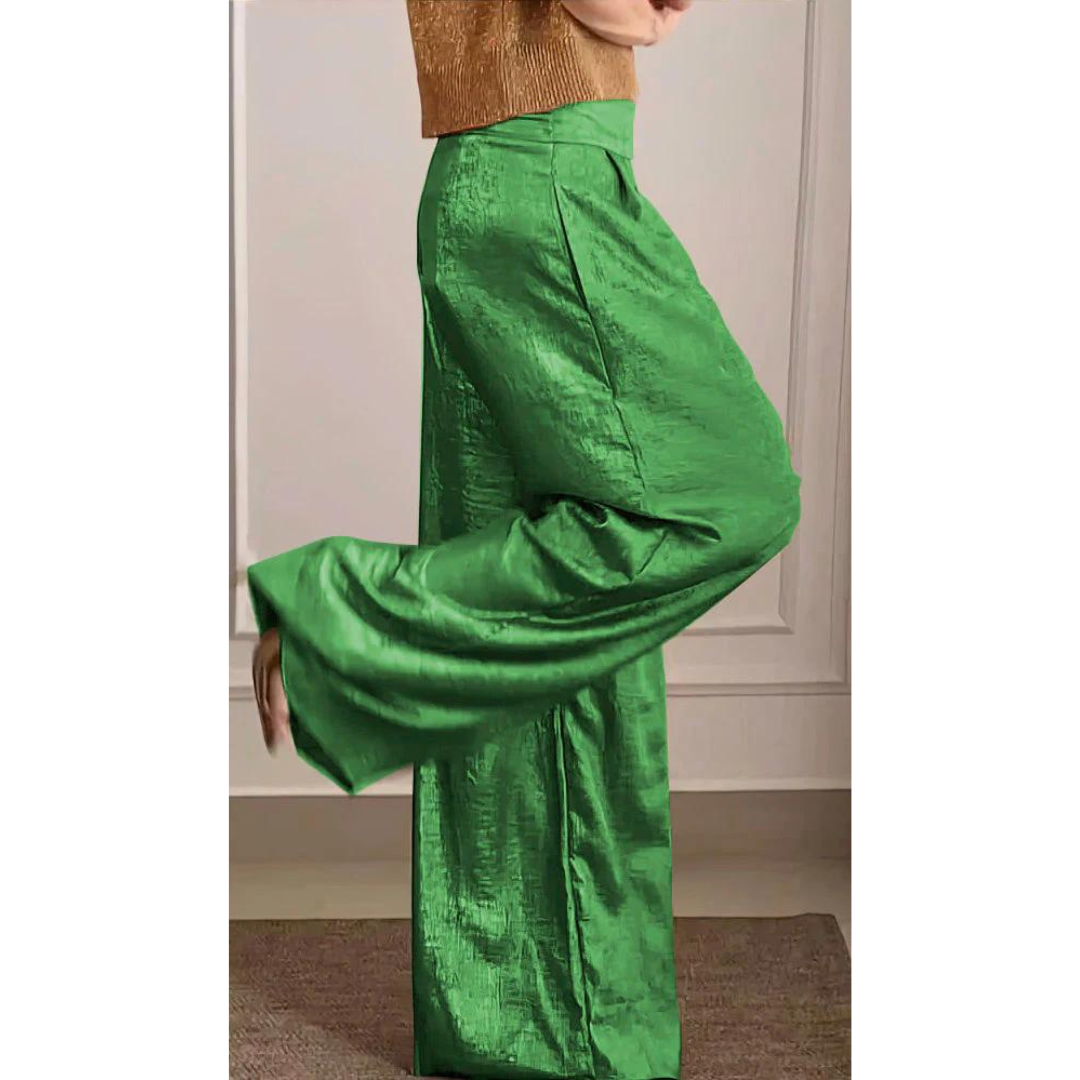 Woman wearing a stylish V-neck top and matching wide-leg trousers on a plain background.