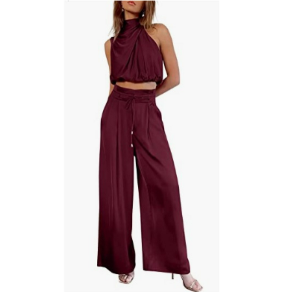 Woman showcasing a coordinated sleeveless top and flowing pants outfit on a plain background.