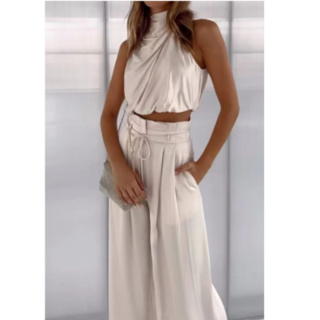 Female wearing a halter-style top and wide-leg pants set on a plain background.