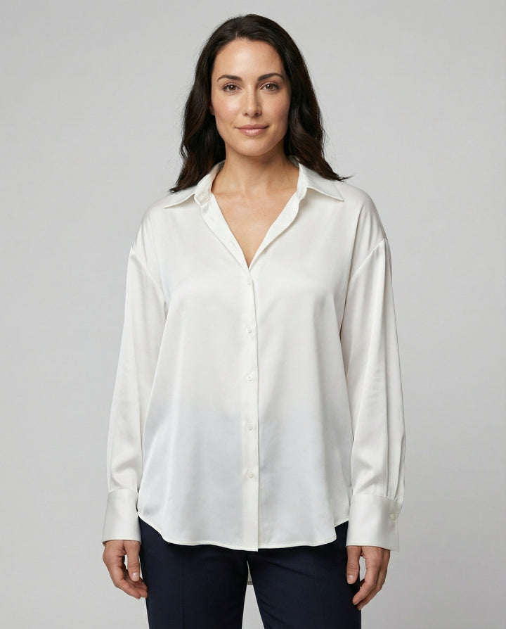 Female model wearing a long sleeve silk blouse on a plain background.
