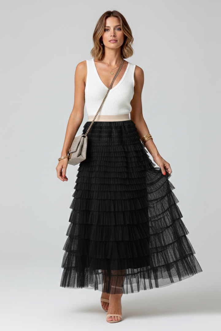 Female model with sling bag posing in flared midi black skirt
