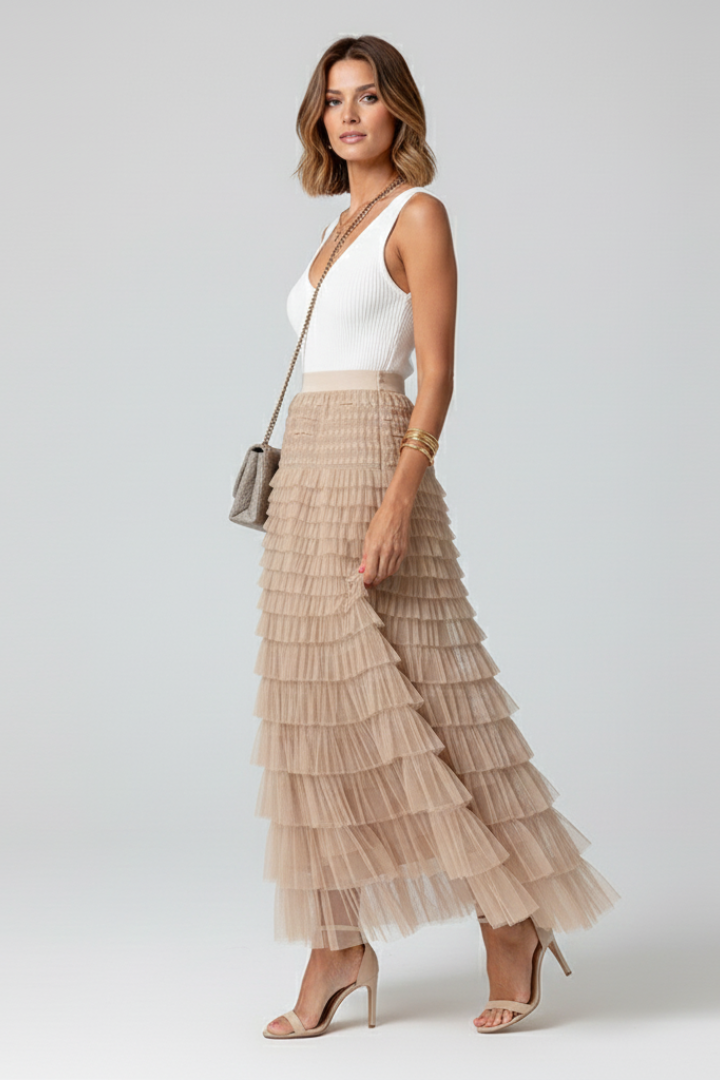 Side model wearing elastic waist tulle skirt full-length, plain background