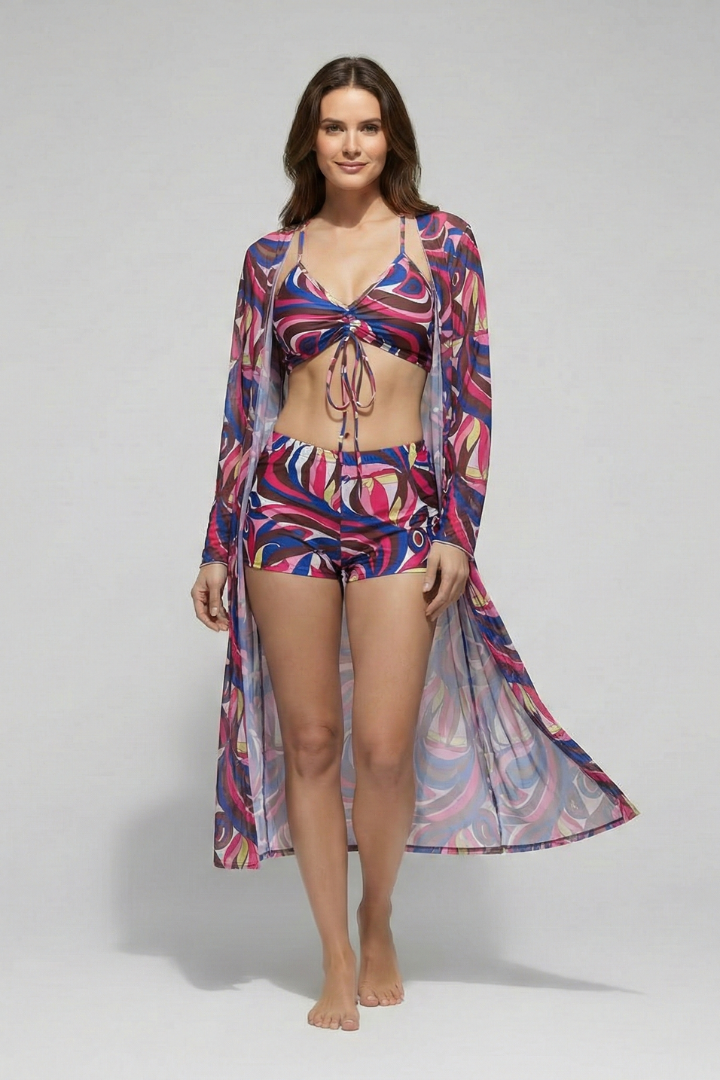  Woman in a V-neck bikini top, matching swim bottoms, and open-front cover-up with an all-over print on a plain background.