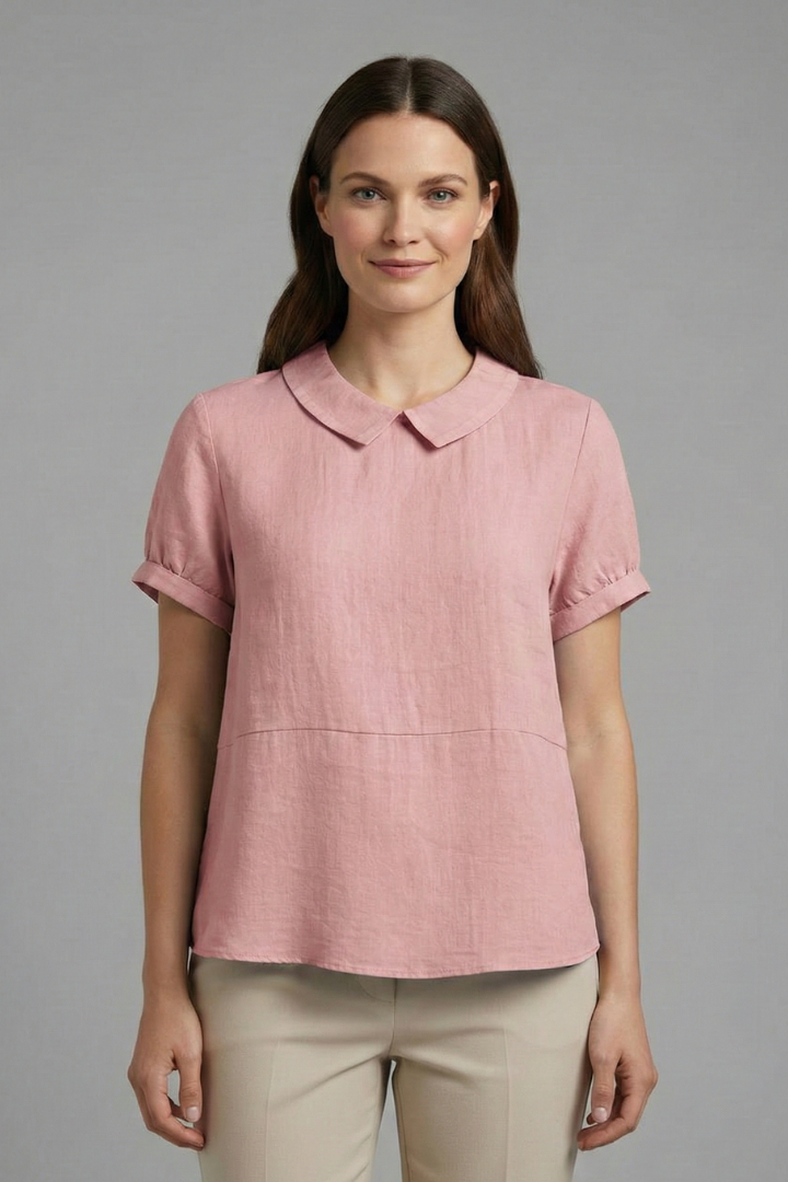 Female model in short sleeve pink blouse hanging on gay background