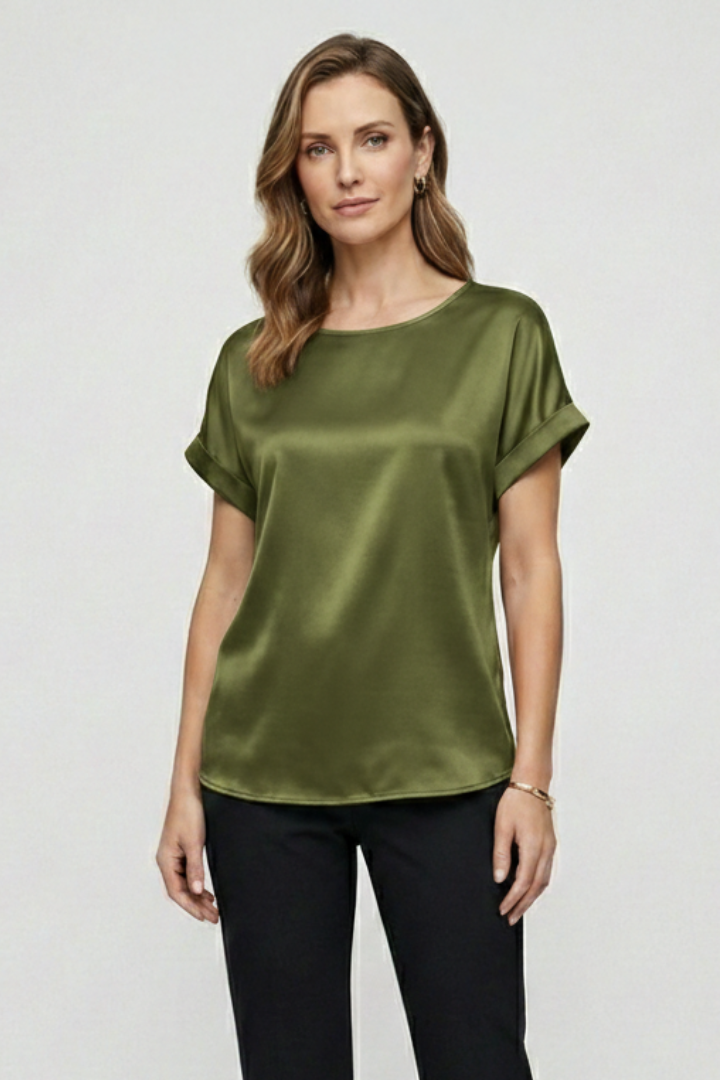 Woman in satin green blouse paired with black pants