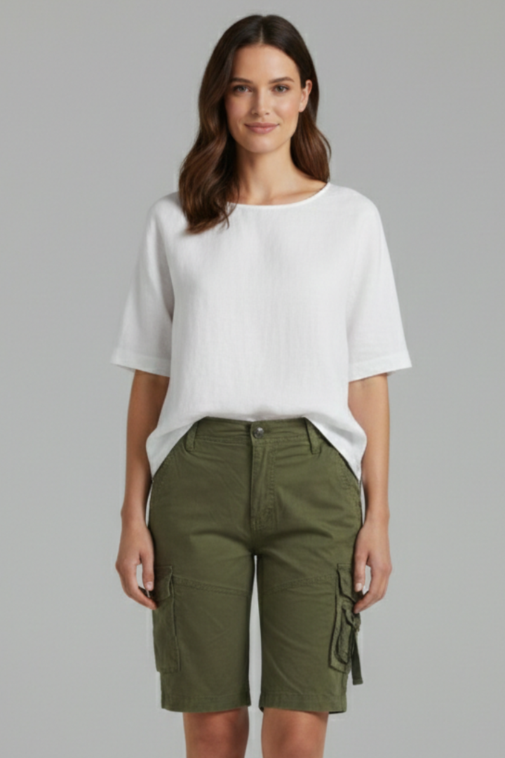 Model wearing cargo army green shorts and white top front view gray background