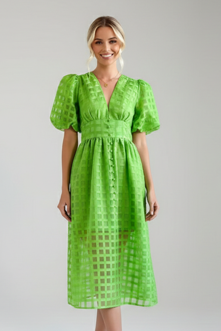 Model posing in textured lace green dress in gray background