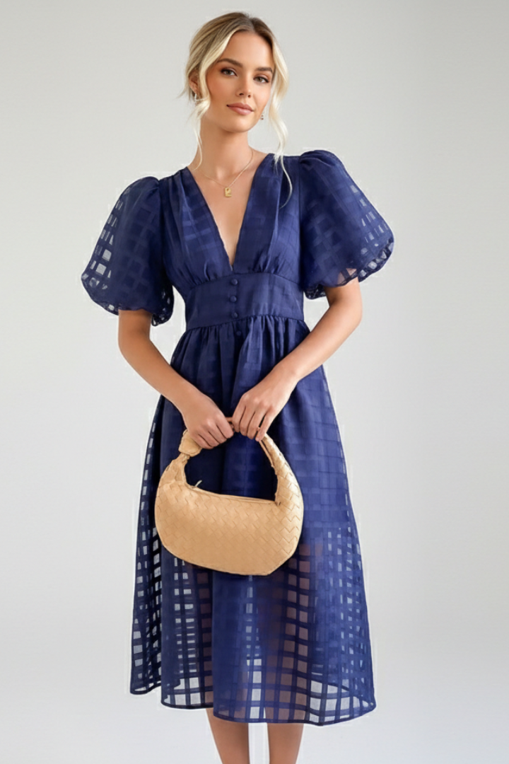 Front angle of model wearing a lace dress in gray background