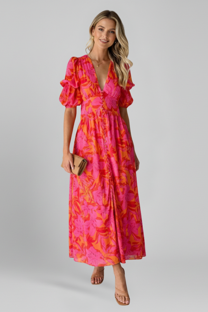Woman wearing printed long dress front view on plain gray background.