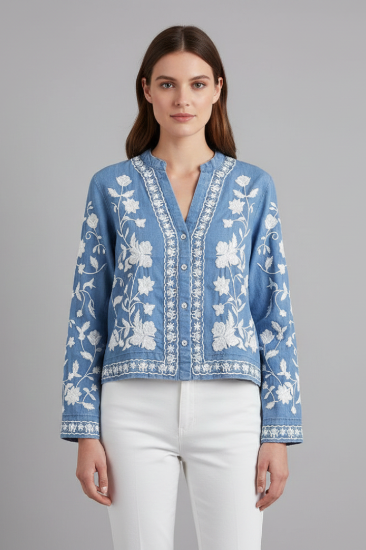 Front facing model in embroidered floral top in clean gray background