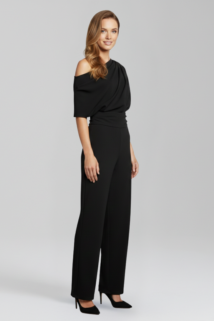 Model wearing a full-length one-piece outfit with wide leg trousers on a plain background.