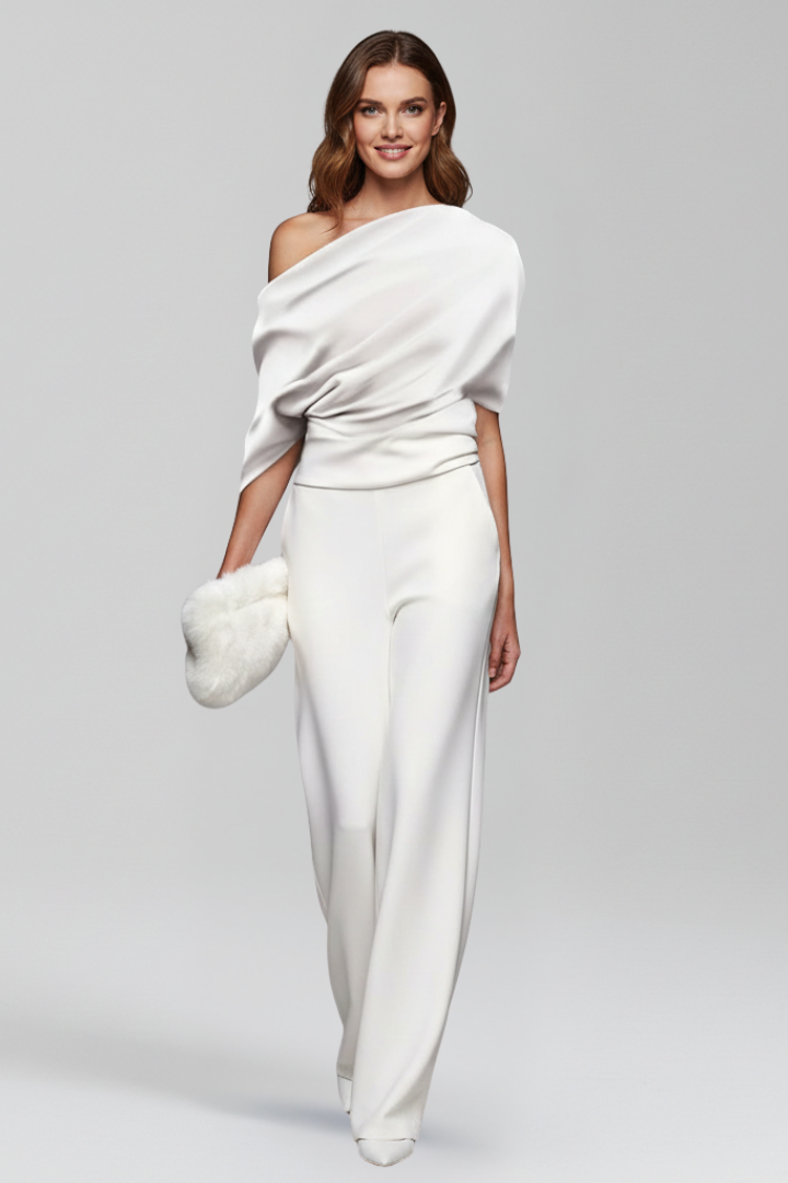 Woman wearing a solid full-length jumpsuit with straight wide leg hems on a plain background.