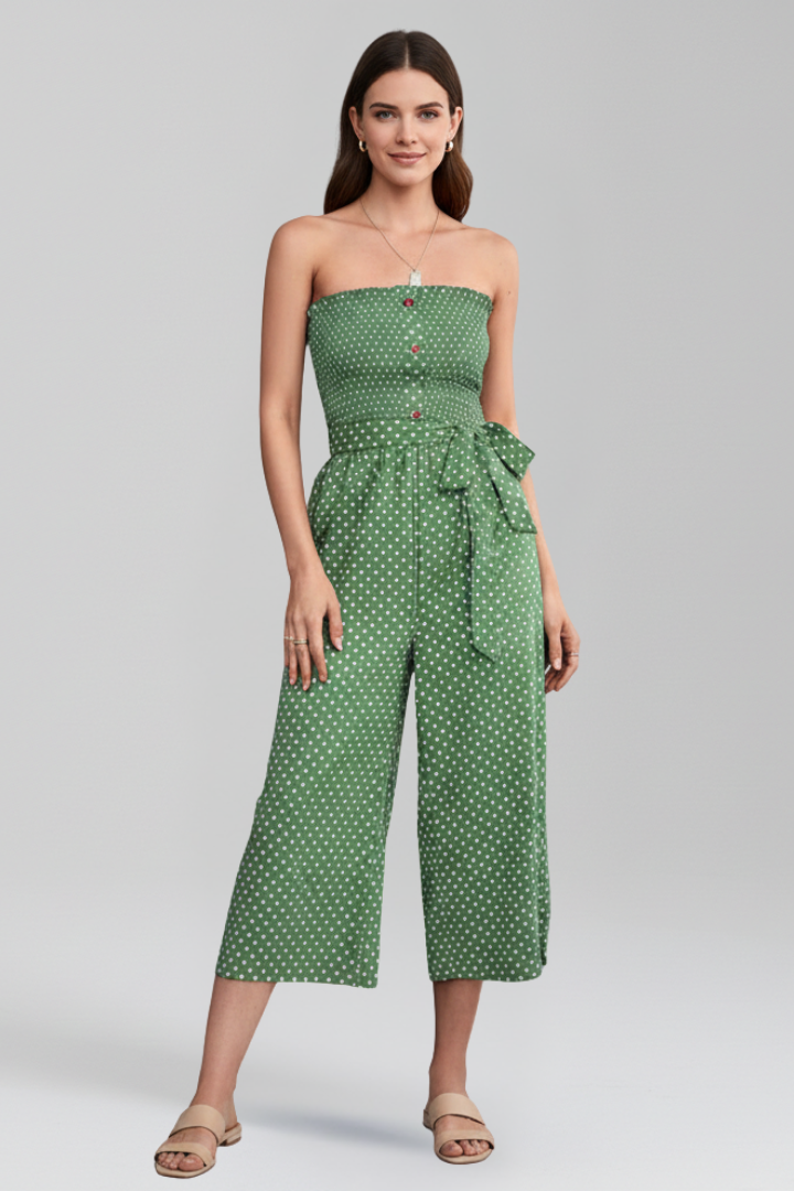 Model wearing a button front women’s jumpsuit with bandeau neckline on a plain background.