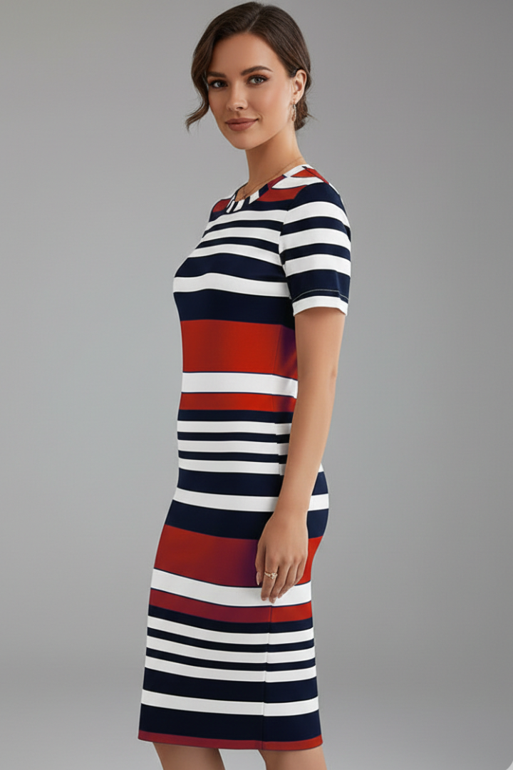 Woman posing in striped dress with round neckline, plain gray background.