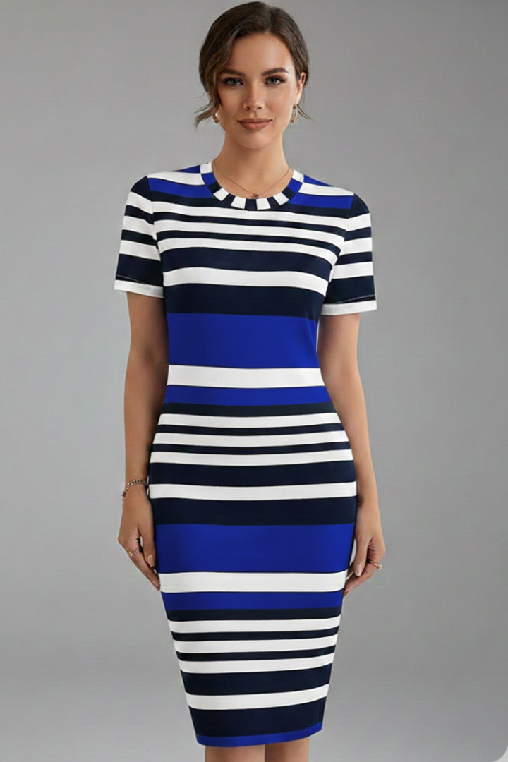 Woman in fitted striped dress standing front on plain gray background.