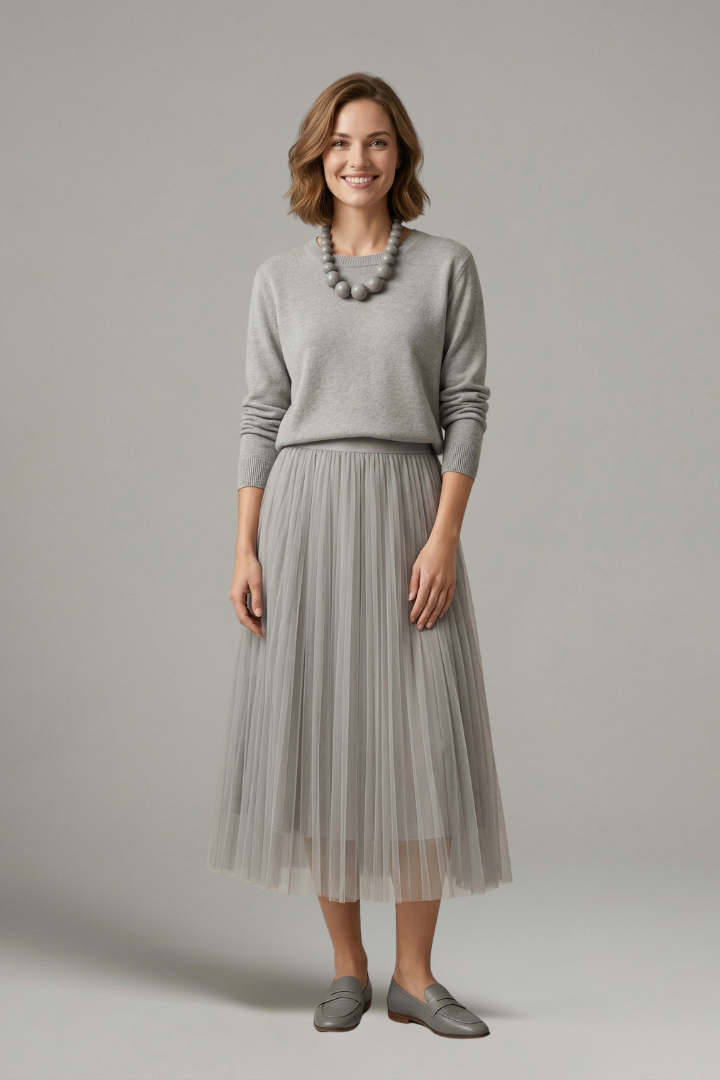 Full length view of model wearing circular necklace in layered dress displayed on gray background