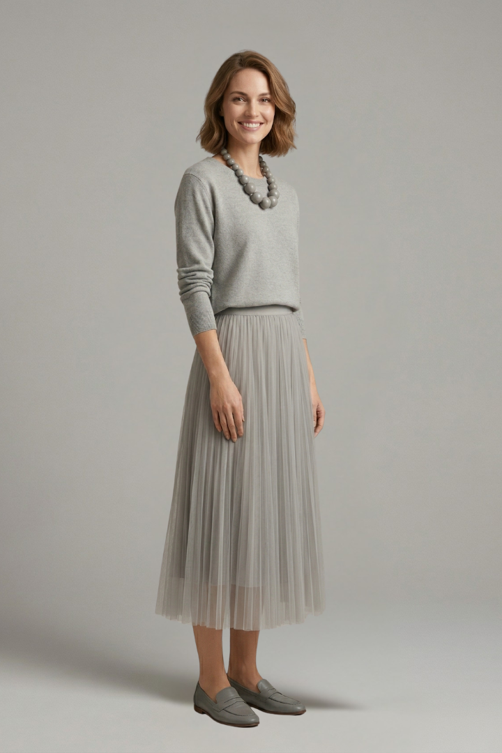 Side angle model in textured dress with pleats gray background