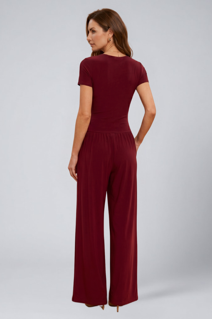 Woman styled in a matching lounge set with full-length wide-leg pants on a plain background.