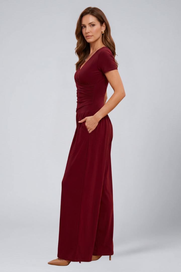 Female model wearing a wrap front blouse with loose-fit pants on a plain background.