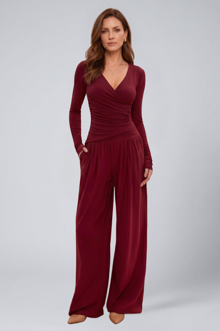 Woman wearing a two-piece woven lounge outfit with side pockets on a plain background.