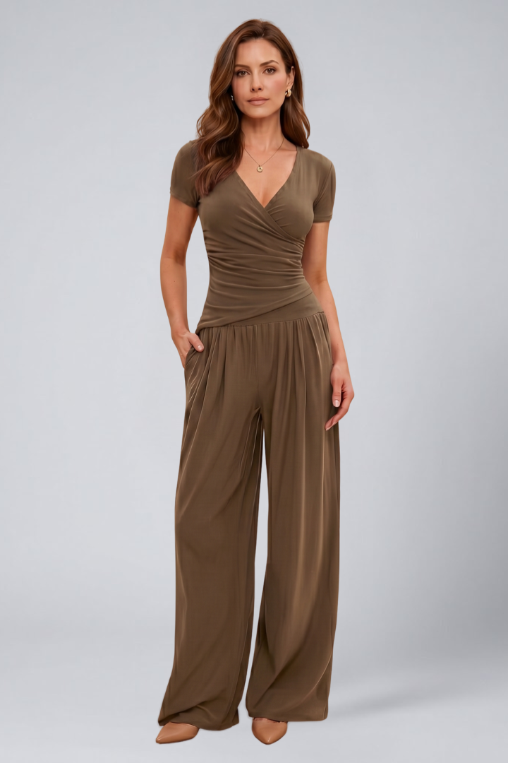 Woman posing in a coordinated V-neck lounge outfit with straight hem pants on a plain background.