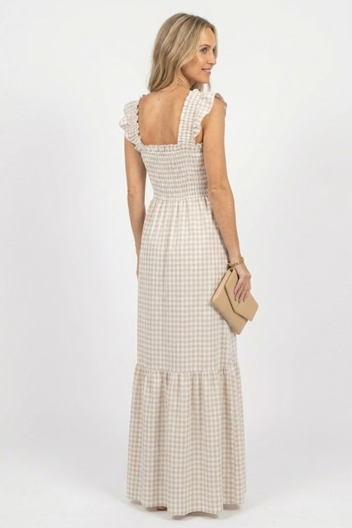 Female model in ankle-length plaid dress back pose gray background.