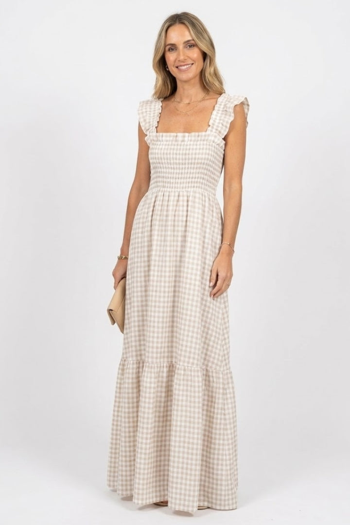 Woman wearing plaid maxi dress front view on plain gray background.