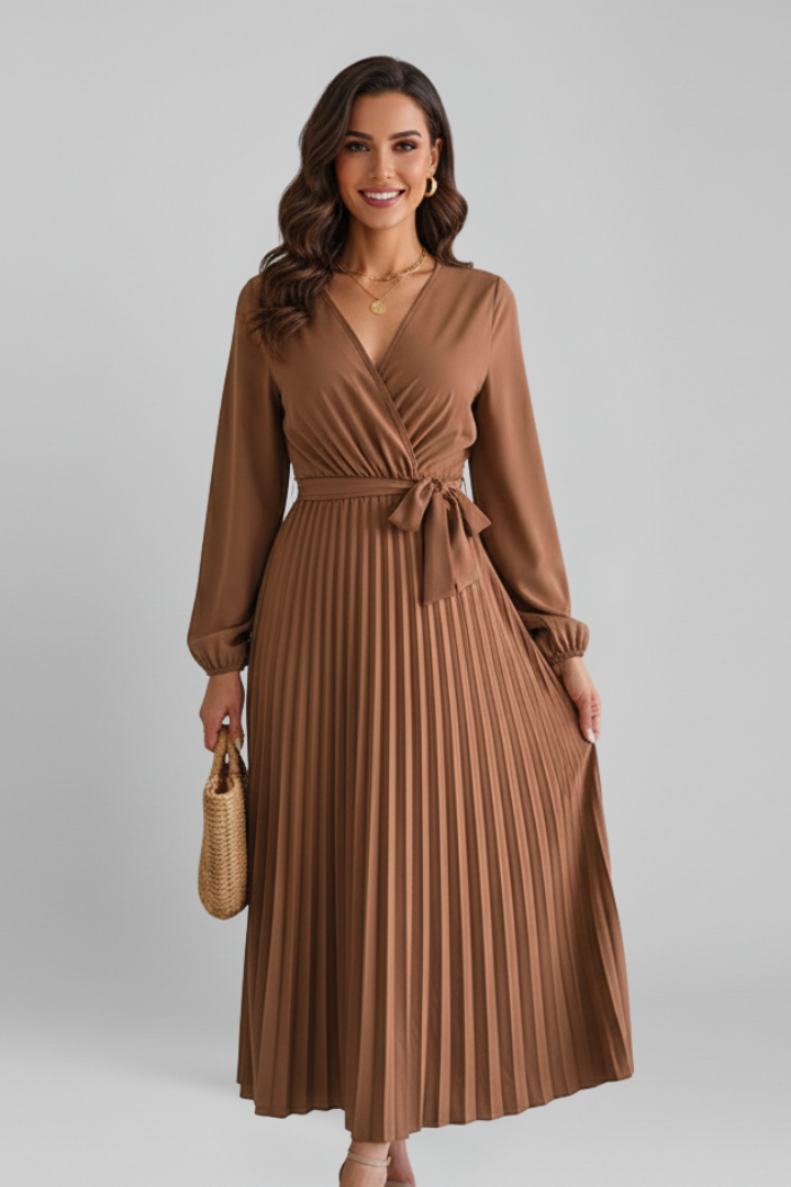 Full length pleated dress modeled on gray backdrop
