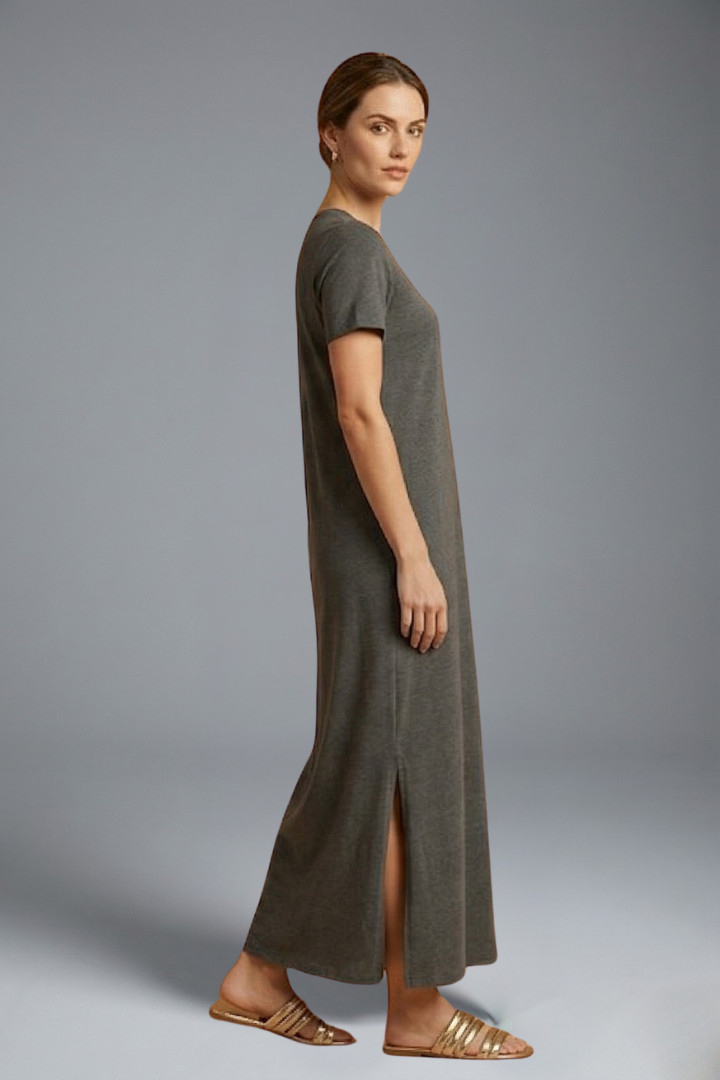 Model side posing in long casual dress on gray background