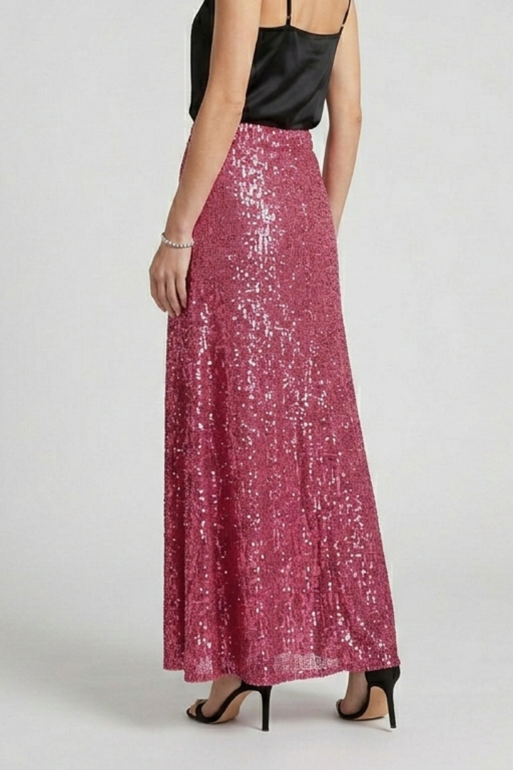 Back pose model wearing long shimmer skirt and black top with black heels