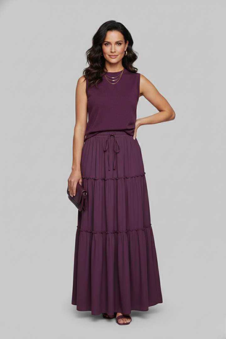 Model wearing tiered purple maxi skirt on gray background
