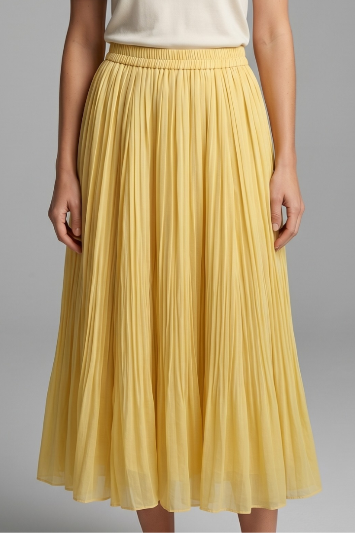 Woman wearing a floor-length pleated skirt with stretch waist on a plain background.