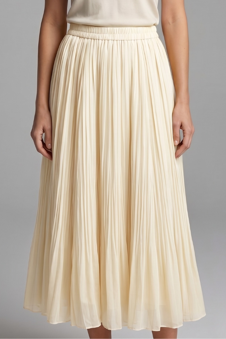 Woman wearing a full-length pleated skirt with a clean waist finish on a plain background.