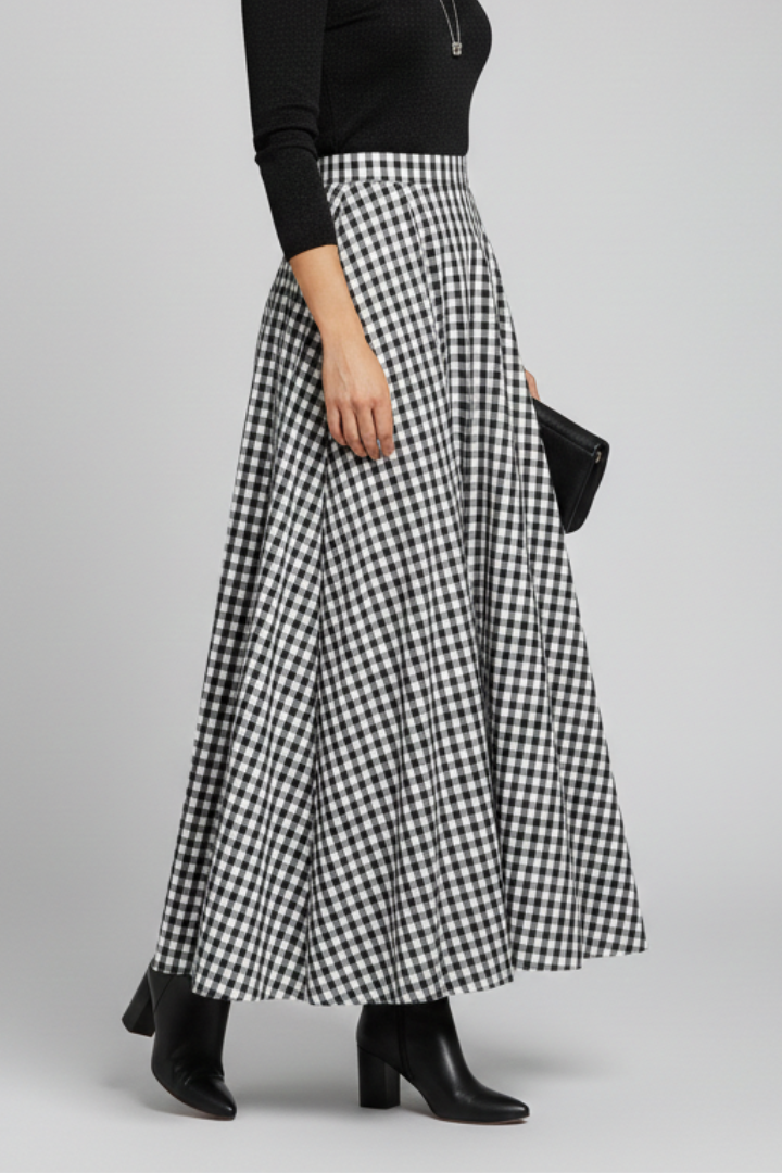 Model showcasing asymmetric hem skirt in gray studio background