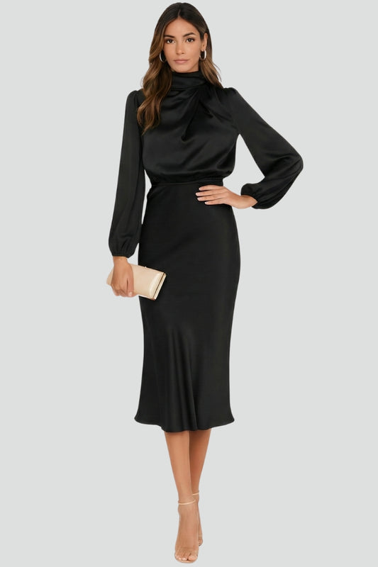 Female model in daily wear midi black dress side pose gray background.