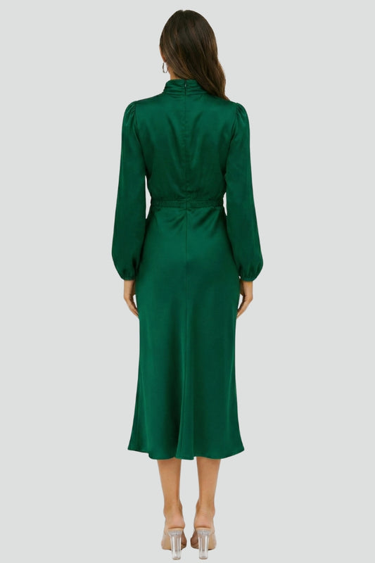 Female model in modest midi dress back view gray background.