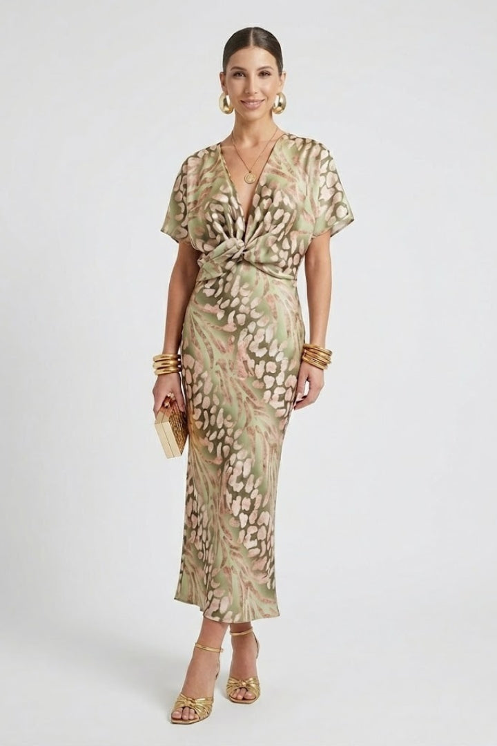 Woman wearing a floral midi dress with pleated skirt on a plain background.